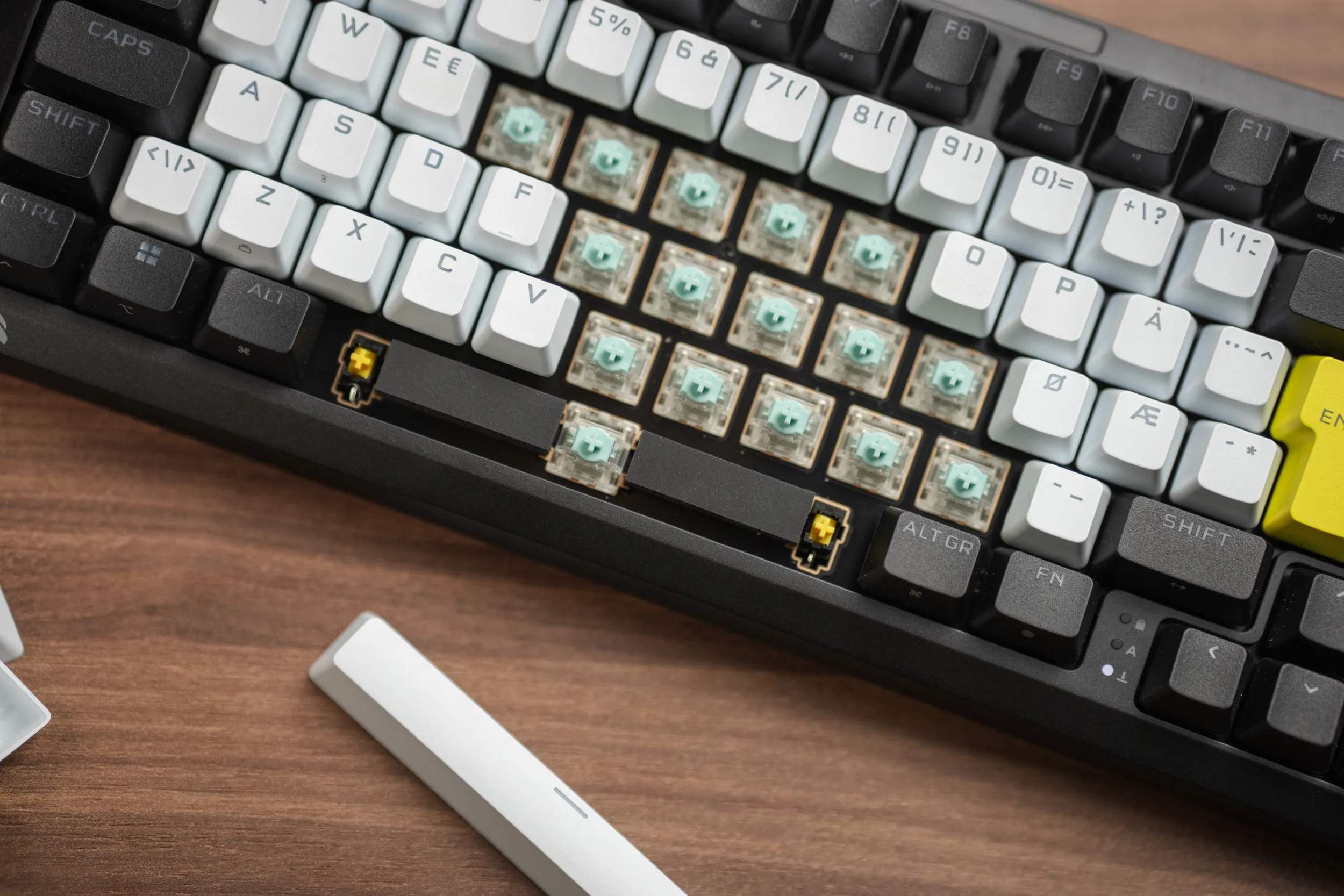 En blokk med keycaps fjernet fra Corsair MAKR PRO 75, som viser de grønne MGX-magnetbryterne montert i hot-swap-soklene