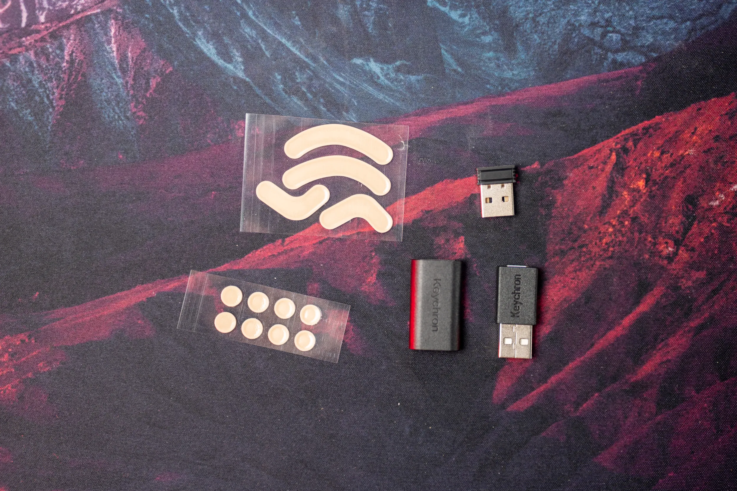 To typer ekstra glides, 2,4 GHz-mottaker, forlenger og USB-A til USB-C-adapter på en musematte