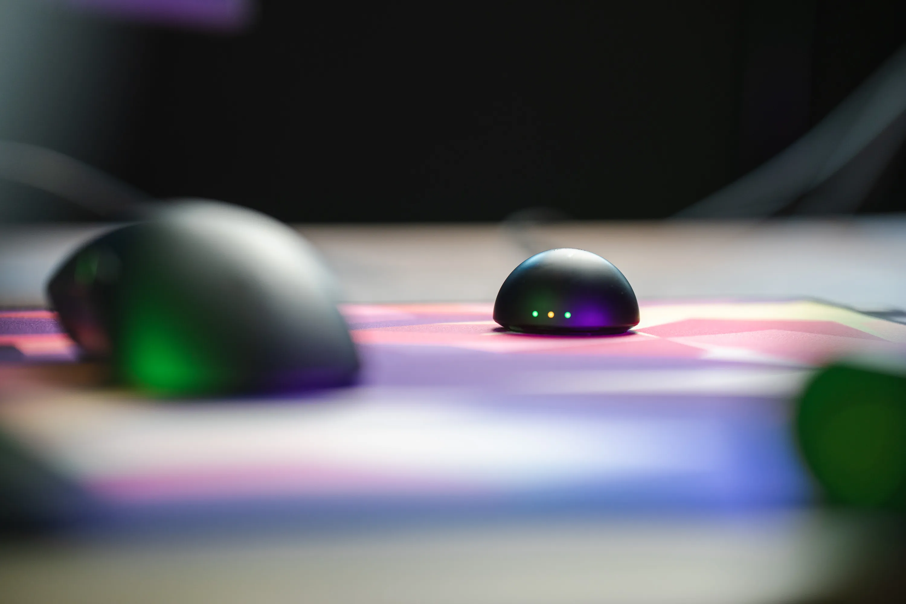 Razer DeathAdder V4 Pro ved siden av mottaker-pucken
