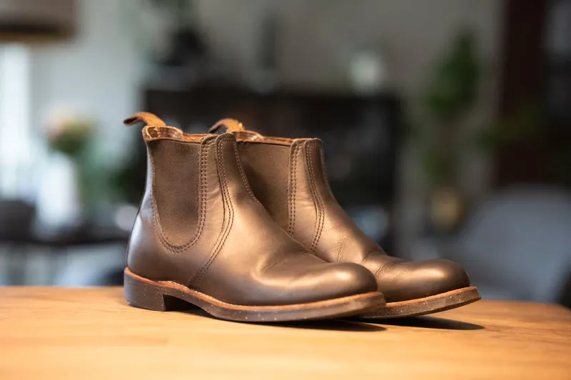 Red Wing chelsea i mørkt skinn sett skrått forfra på trebord