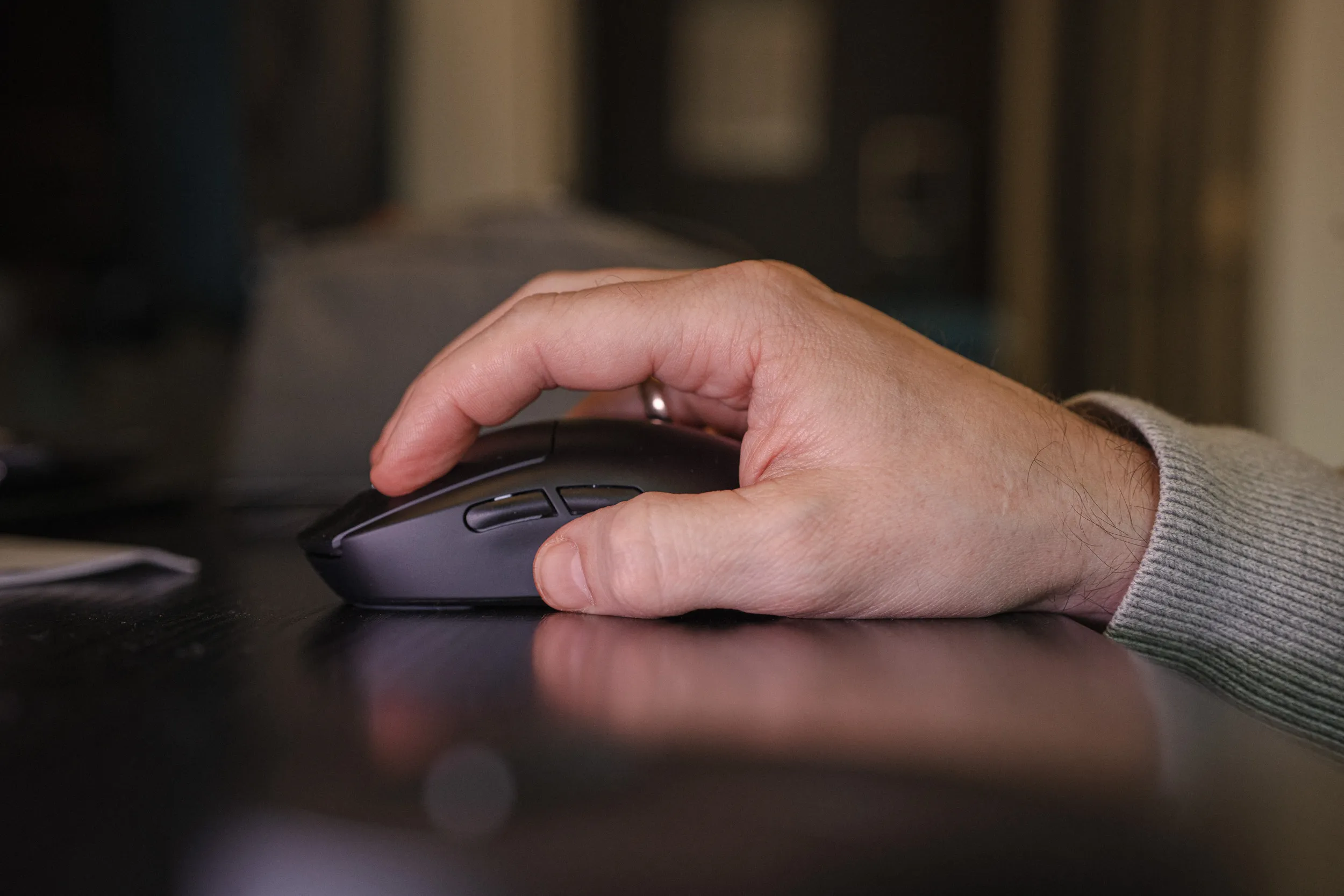 Hånd på Logitech G Pro X Superlight 2 sett fra siden, med tommelen ved sideknappene