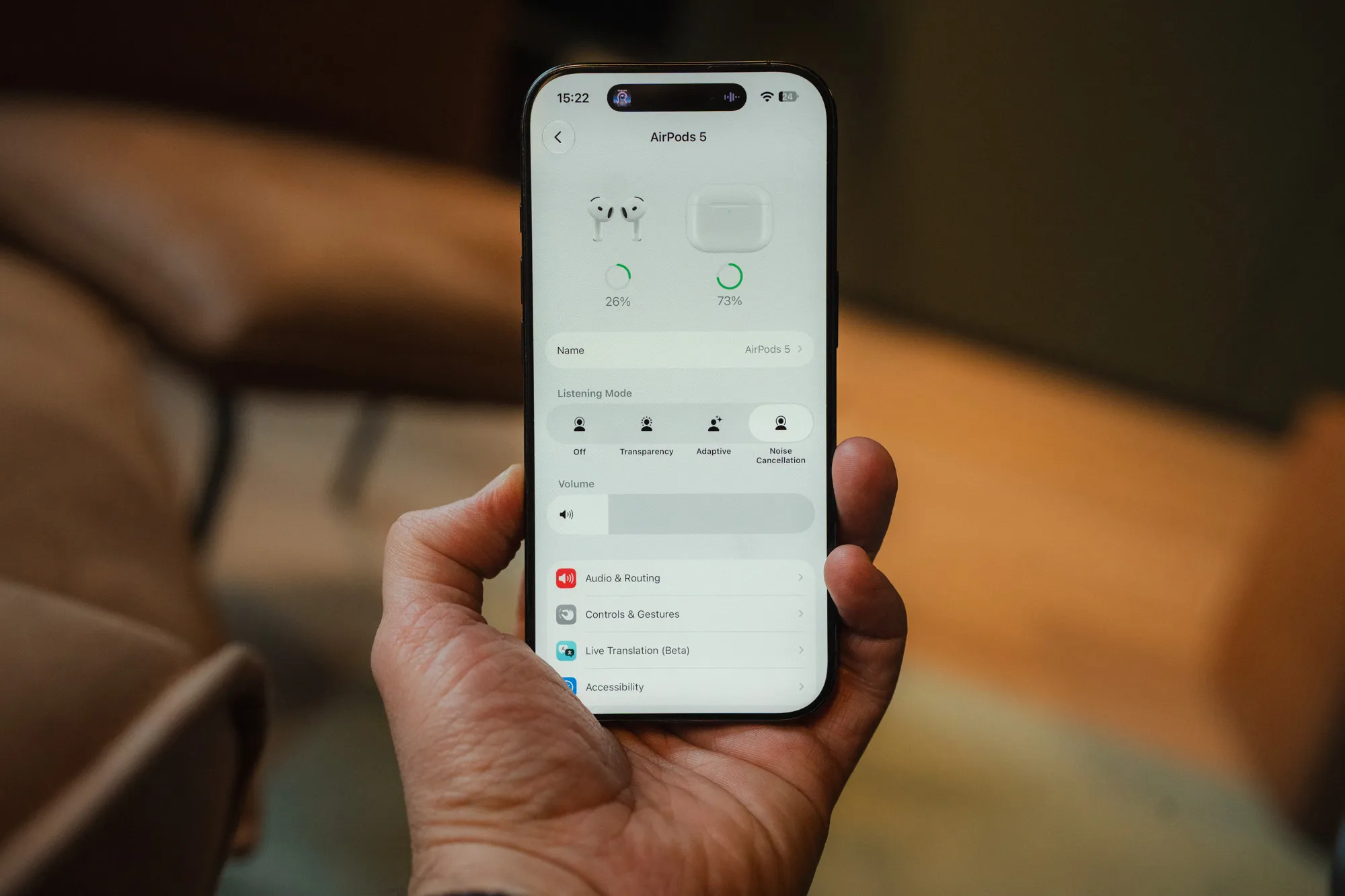 iPhone i handa som viser innstillingene for AirPods 5, med lyttemodus satt til støyreduksjon