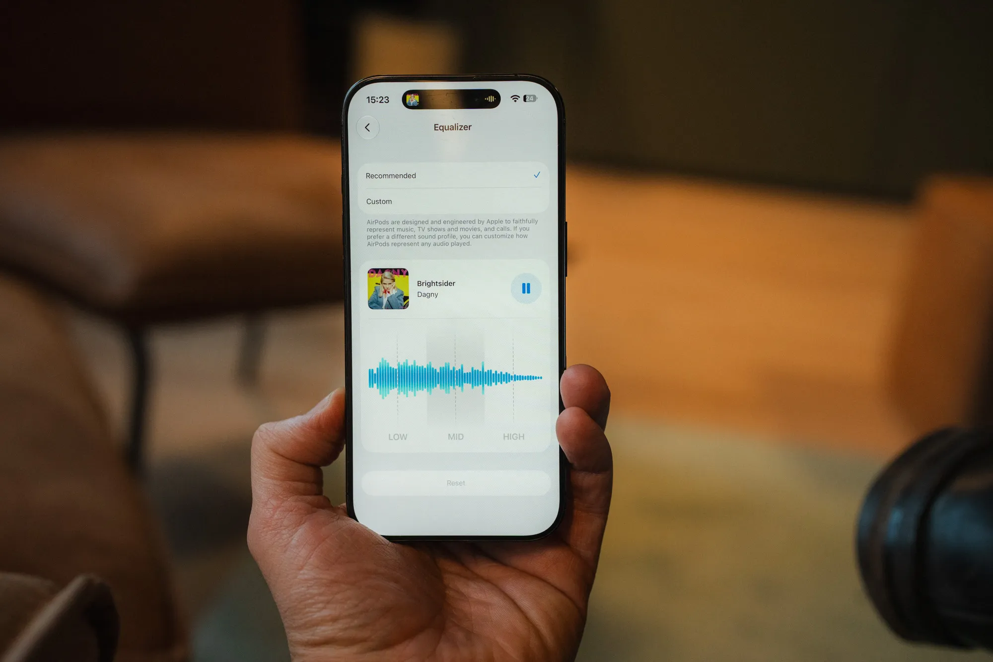 iPhone i handa som viser den nye equalizeren i iOS 27 med tre bånd, lav, mid og høy