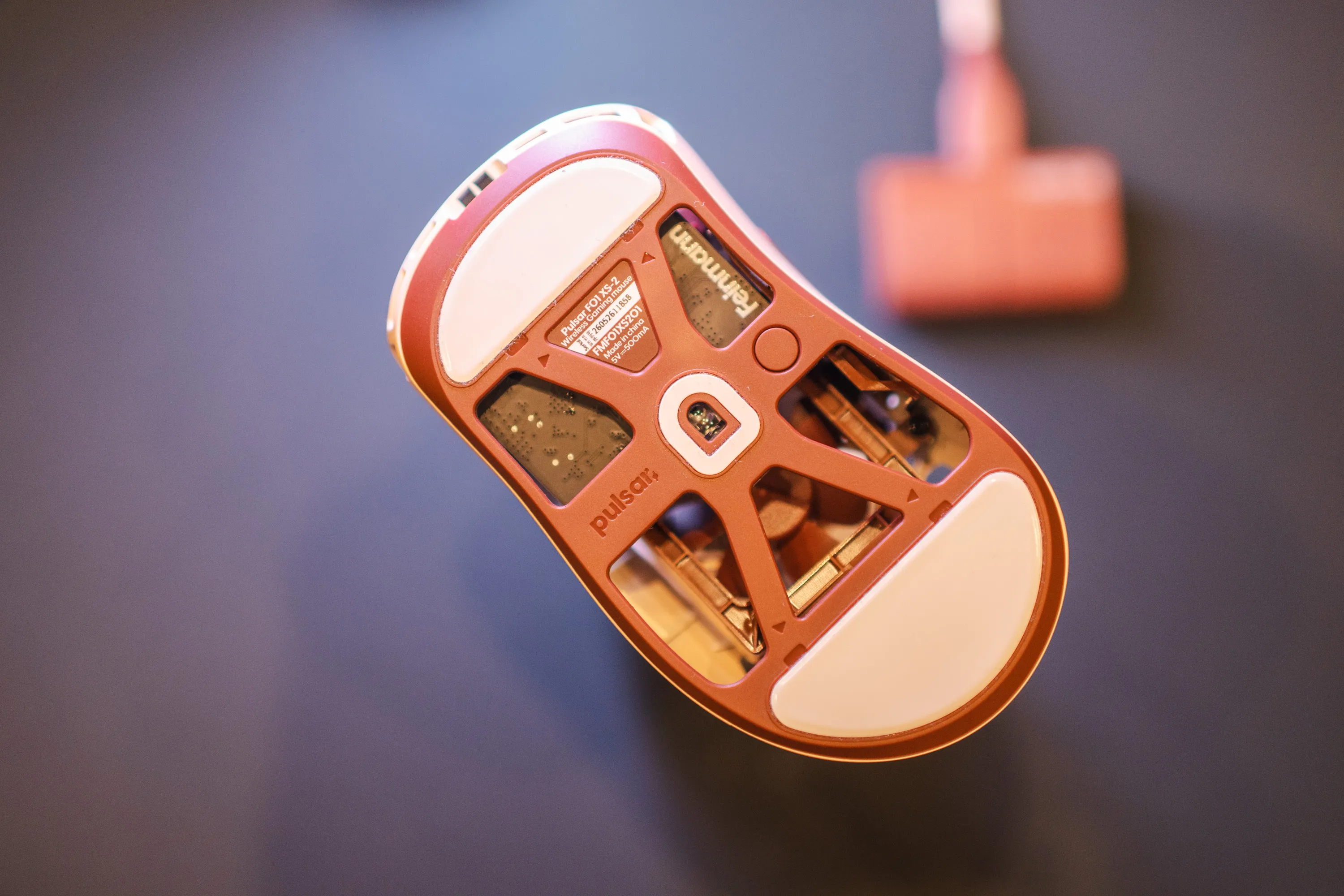 Undersiden av Feinmann F01 Noctua Edition med sensor, skates og produktetikett, mottakeren uskarp i bakgrunnen