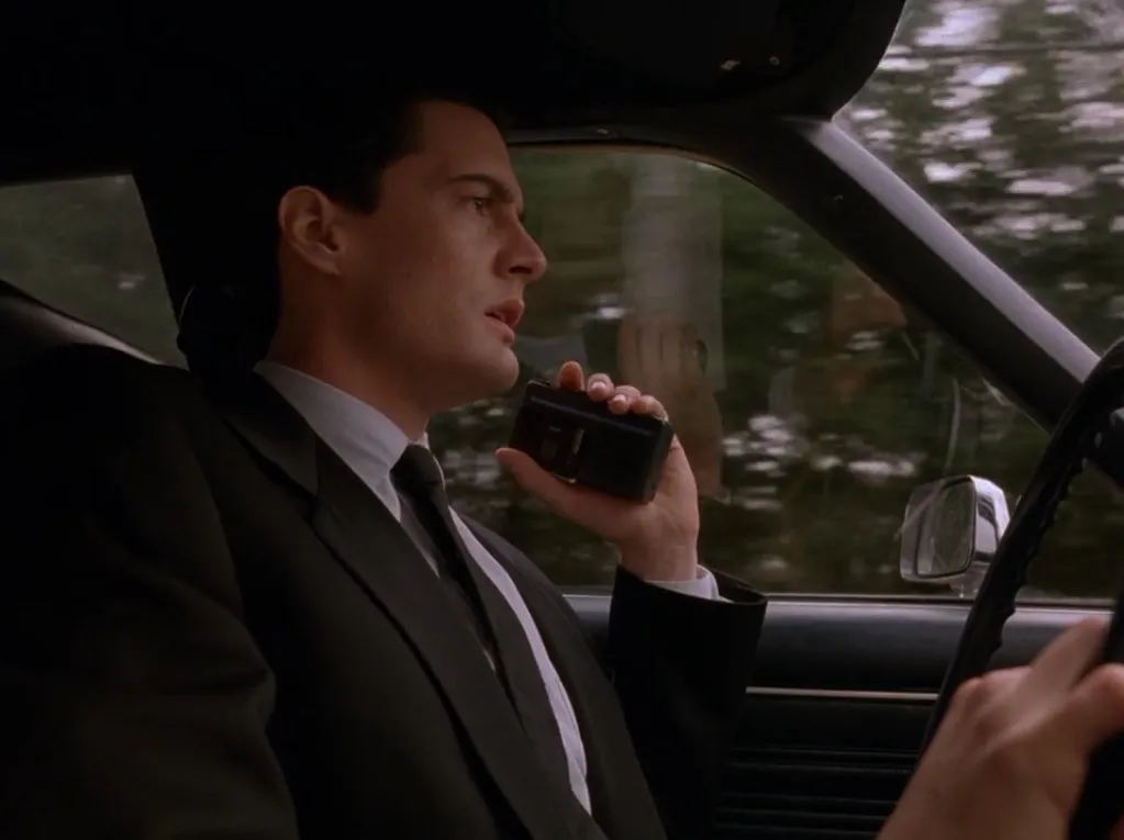 Agent Dale Cooper sitter i bil og snakker inn i en håndholdt mikrokassettopptaker