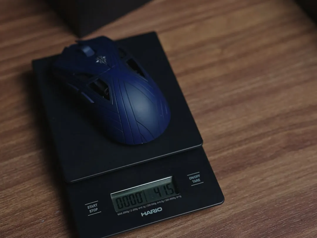 Finalmouse SLX Nightfall på en Hario-kaffevekt på en trepult, der displayet viser 41,5 gram