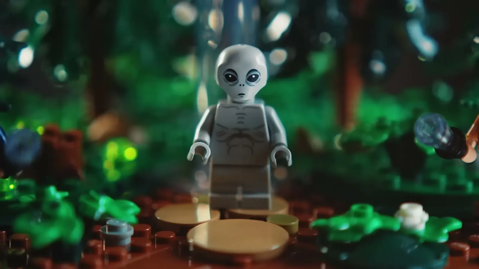 Minifigur av en grå alien i en LEGO-skog med grønt lys