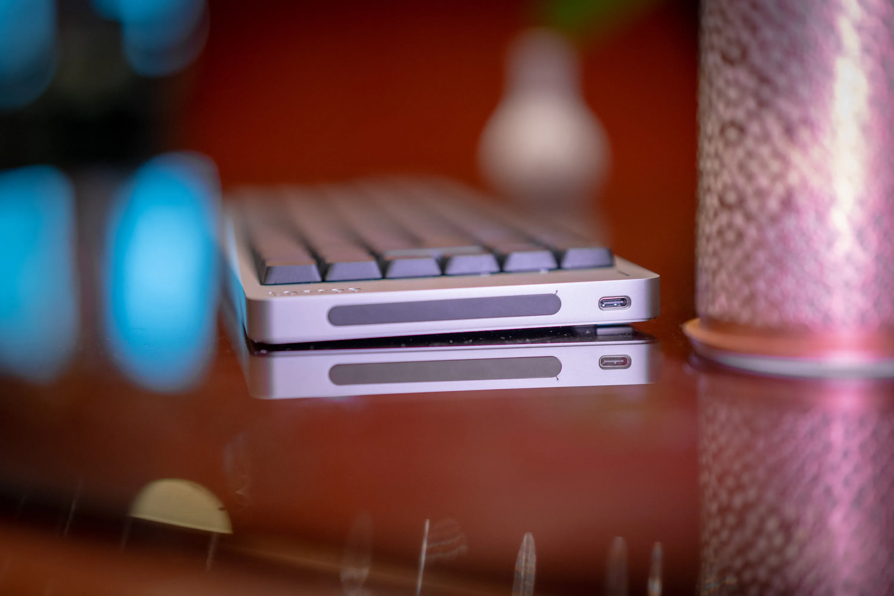 Høyre kortside av Lofree Flow 2 på glassbordet, med touch-baren og USB-C-porten speilet i glasset