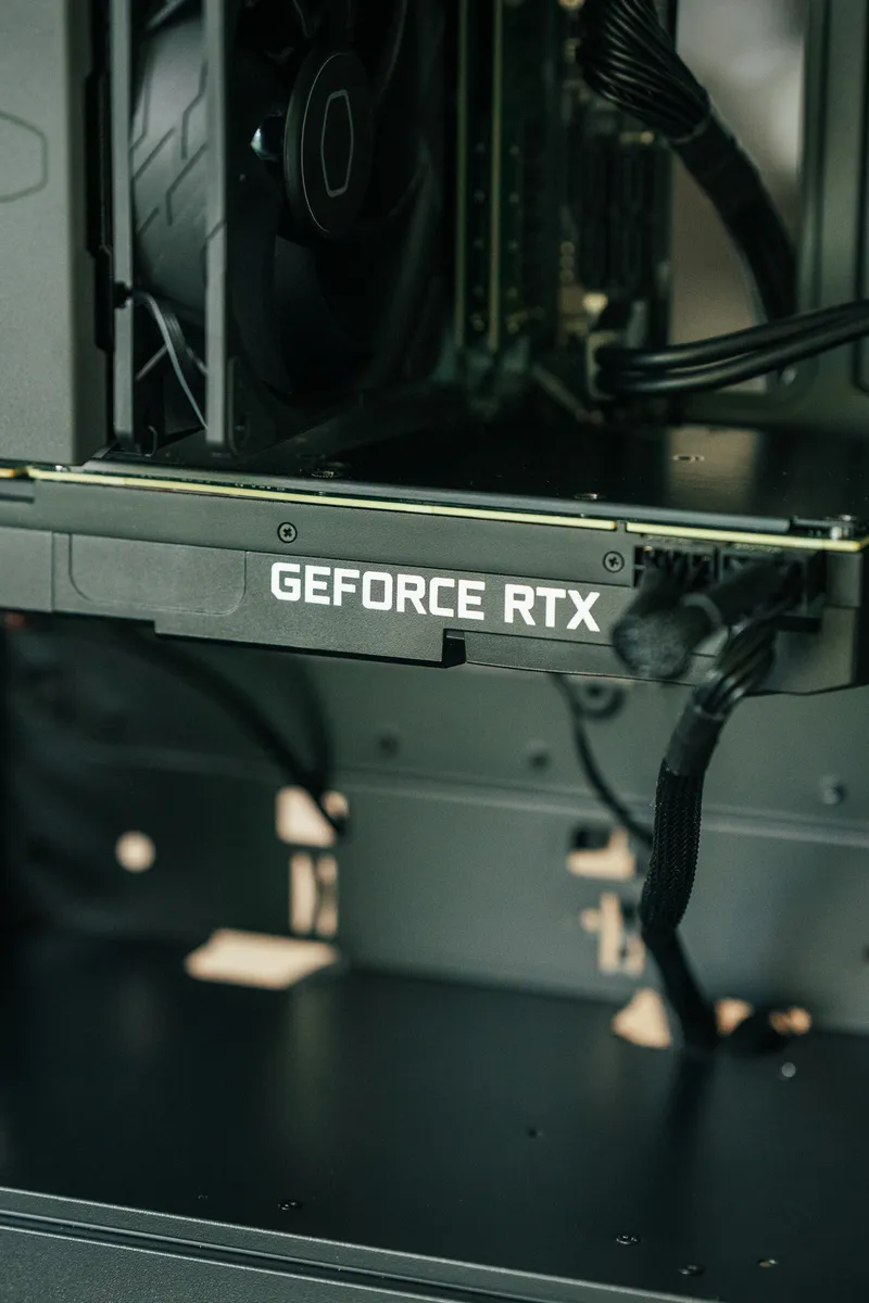 Nærbilde av GeForce RTX-logoen på 2080 Ti, med CPU-kjøleren og DDR4-minnet over