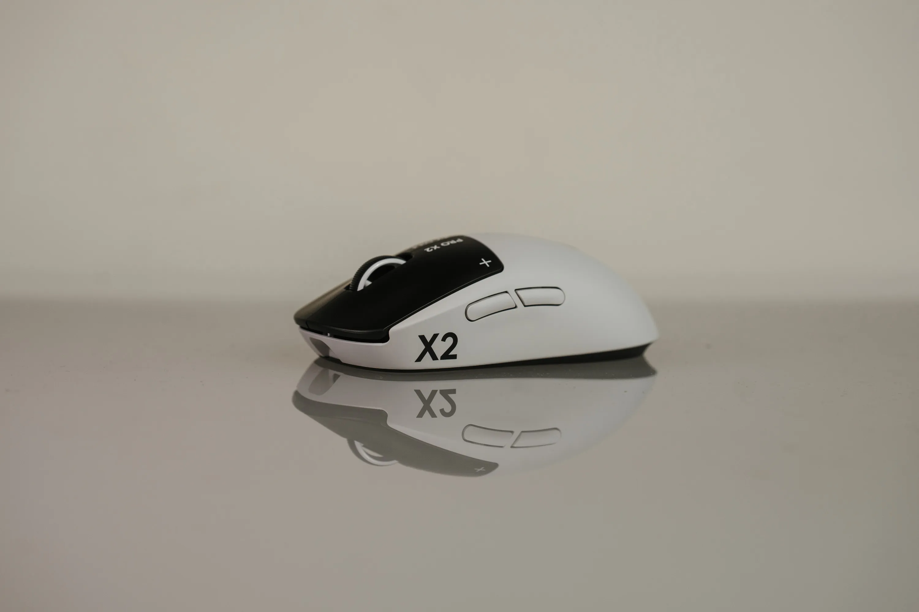Logitech G Pro X2 Superstrike i hvitt sett fra siden, speilet i bordflata